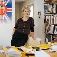 Eine Frau stützt sich lässig an einen Stuhl mit Schafsfell. Auf dem Schreibtisch davor ein Stabel druckfrischer gelber Bücher, ein mit dem Buchcover bezogener Laptop sowie weitere Papiere. Im Hintergrund eine offene Schiebetür, rechts davon ein schmales Bücherregal, links ein Filmplakat. Auf dem Plakat ist der britische Union Jack und eine Sumo-Ringerin abgebildet; oben steht "Club der starken Frauen", unten "Ein Film über die Liebe, übers Dicksein und den Traum, dass jeder eine Chance hat" sowie "MAKE YOUR FAT FUNCTIONAL".