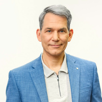 Dr. Urban Pappi Portrait eines grauhaarigen Herrn in hellblauem Jackett und beigefarbenem Polohemd.