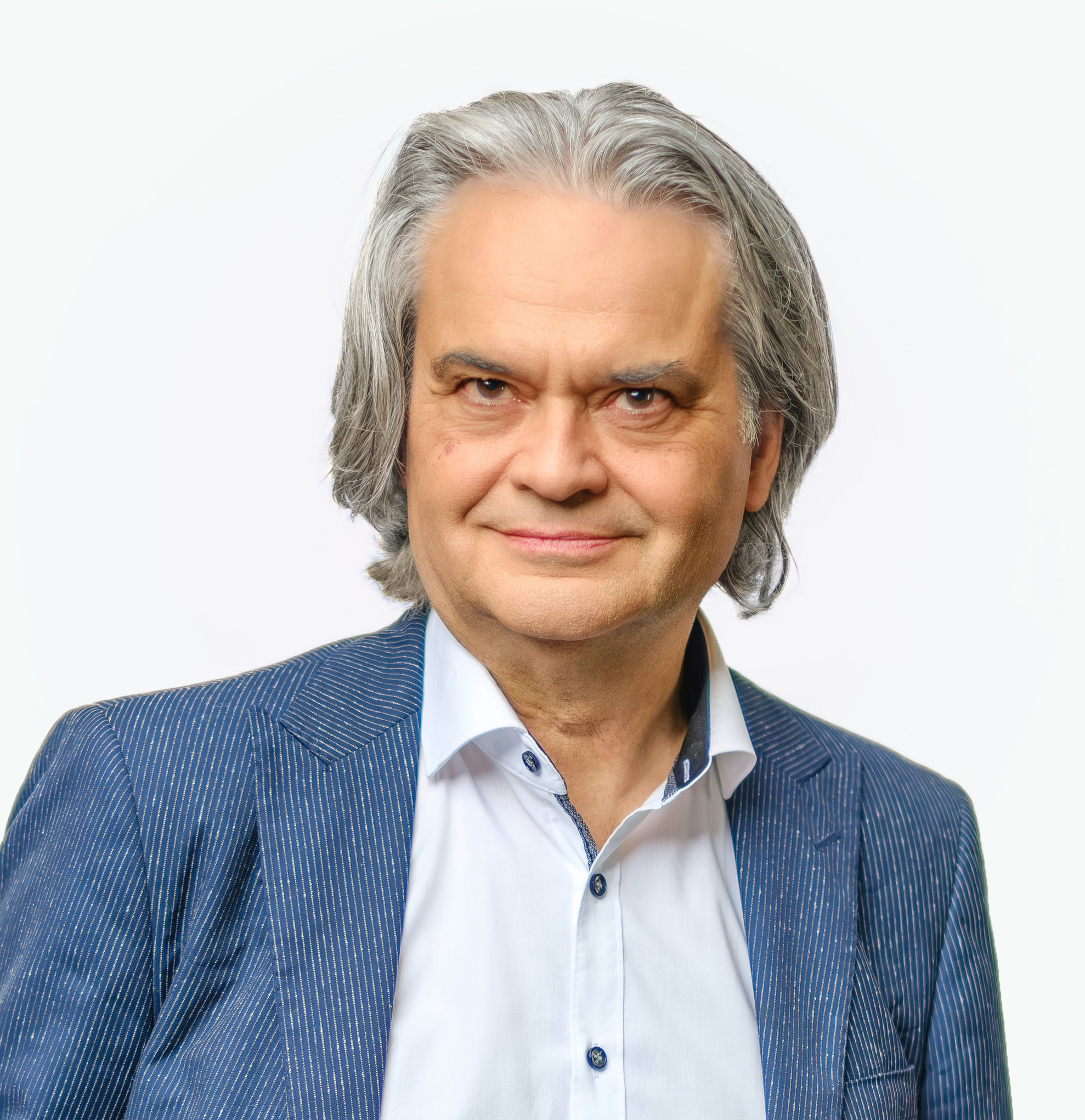 Portrait eines Herrn mit kinnlangem, grauen Haar, weißem Hemd und blauem Jackett.
