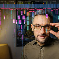 Ein Mann mit Bart schaut direkt in die Kamera, mit einer Hand greift er zu seiner Brille. Im Hintergrund sind zwei Lampen und ein Bild angedeutet. Über dem Foto liegt die vollständige Timeline eines Films.